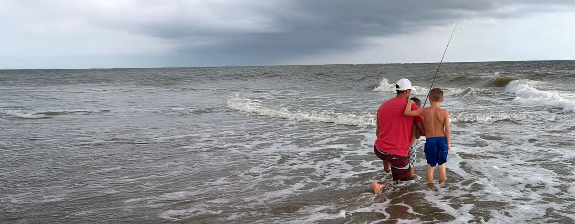 Two people fish in the ocean as Charleston Fishing Rentals provides fishing gear rentals Charleston SC in Isle of Palms, South Carolina.