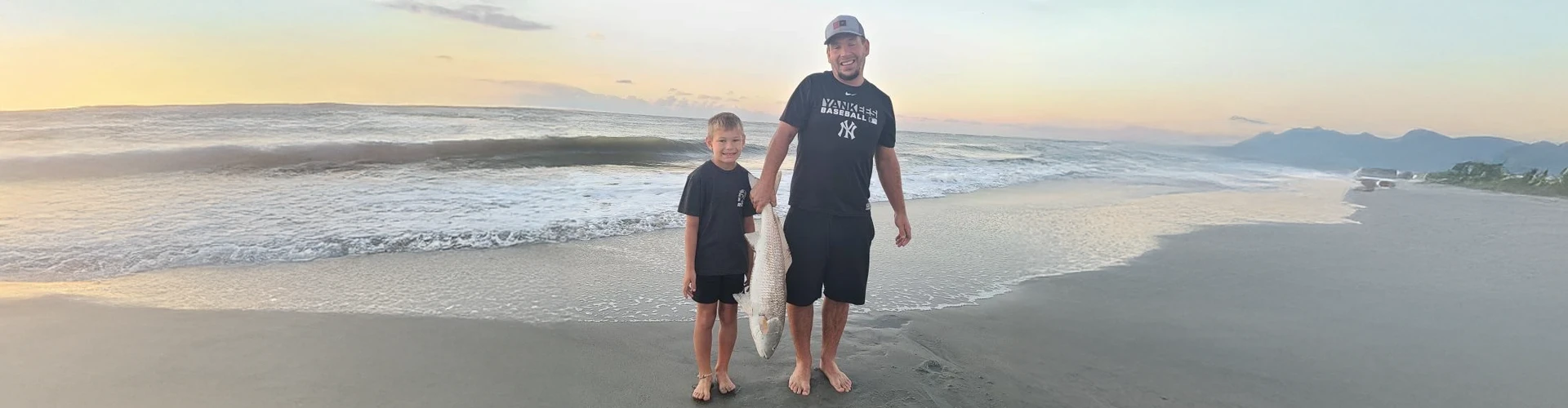 A man and boy on the beach use fishing gear rentals Charleston SC from Charleston Fishing Rentals in Isle of Palms, South Carolina.