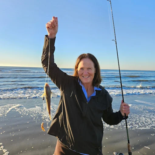 Holding a rod, a woman uses fishing rod and reel rental Charleston from Charleston Fishing Rentals in Isle of Palms, South Carolina.