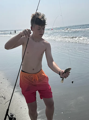 A boy on the beach enjoys time near beach fishing equipment rental Charleston from Charleston Fishing Rentals in Isle of Palms, South Carolina.