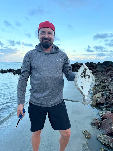 A man on the beach uses surf fishing gear rental Charleston from Charleston Fishing Rentals in Isle of Palms, South Carolina.