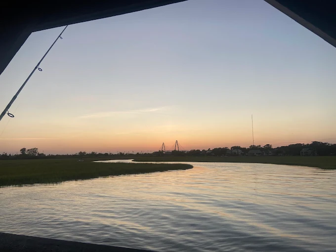 A boat at sunset reflects trips supported by fishing gear rentals Charleston SC from Charleston Fishing Rentals in Isle of Palms, South Carolina.