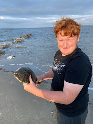 A small fish is held using fishing tackle rental Charleston SC from Charleston Fishing Rentals in Isle of Palms, South Carolina.