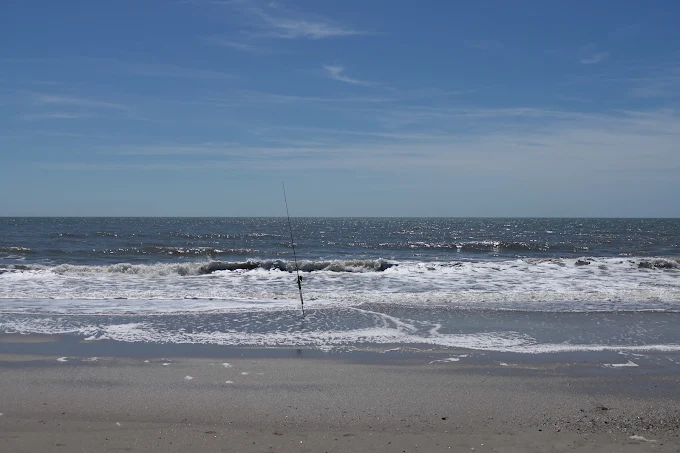 A fishing rod on the beach reflects surf fishing gear rental Charleston by Charleston Fishing Rentals in Isle of Palms, South Carolina.